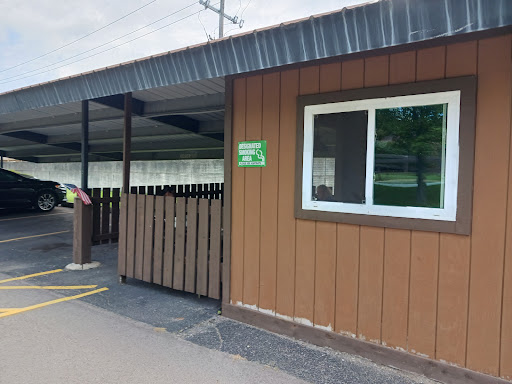 Exterior view of a building with wooden siding and a fenced entrance.