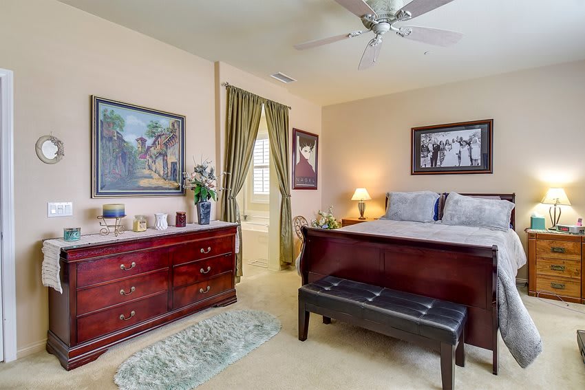 A cozy bedroom with classic furniture and decorative artwork on the walls.