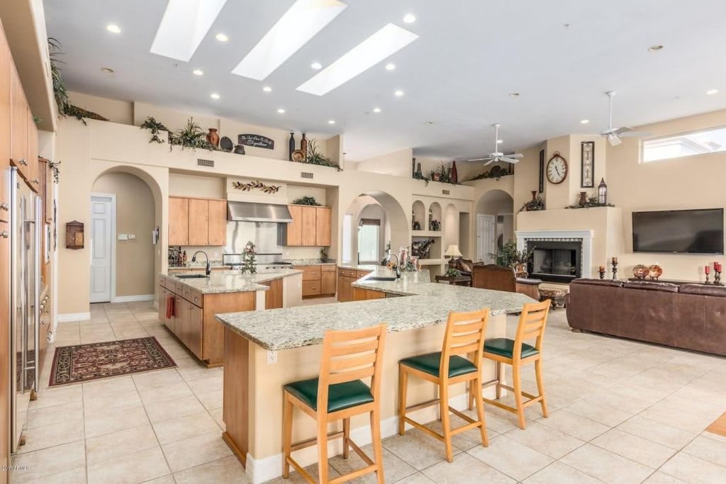 A spacious and modern kitchen with an open floor plan, featuring a large island and seating.