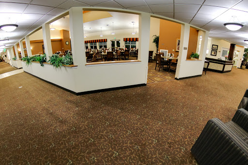 A spacious dining area featuring tables, chairs, and decorative plants.