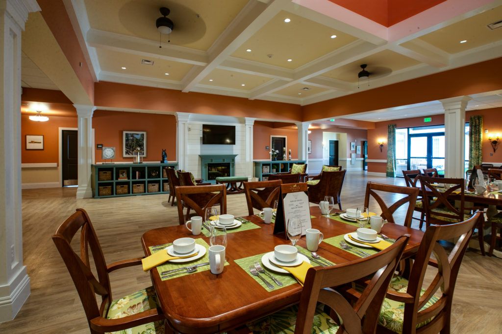 A well-decorated dining room featuring neatly arranged tables with place settings, warm lighting, and elegant interior decor.