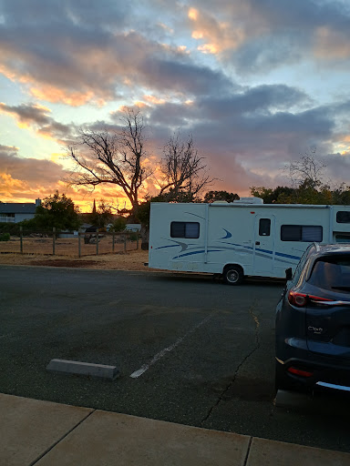 A serene sunset view featuring an RV parked in a campground.