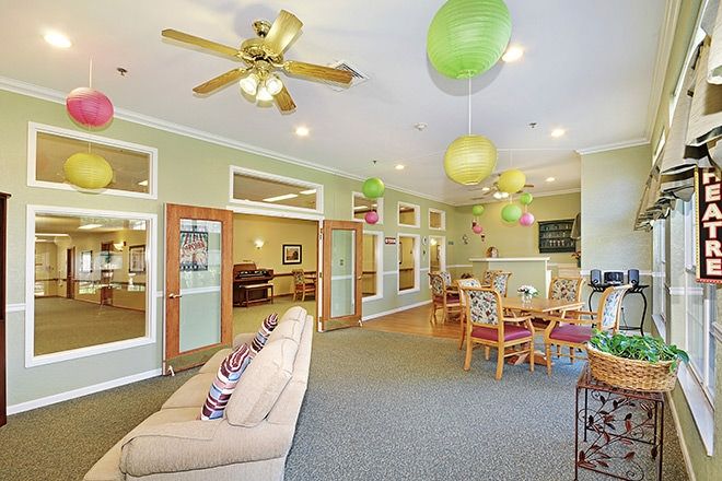 A cozy living room with sofas, a table, and colorful decorations hanging from the ceiling.