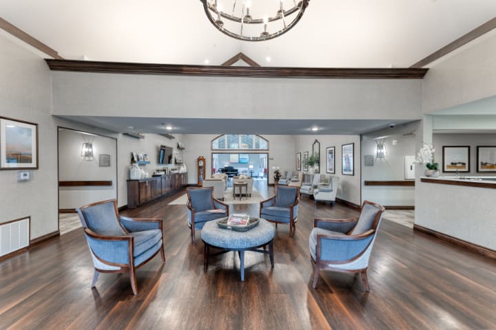 A spacious and elegantly designed lobby with a circular seating arrangement and hardwood flooring.