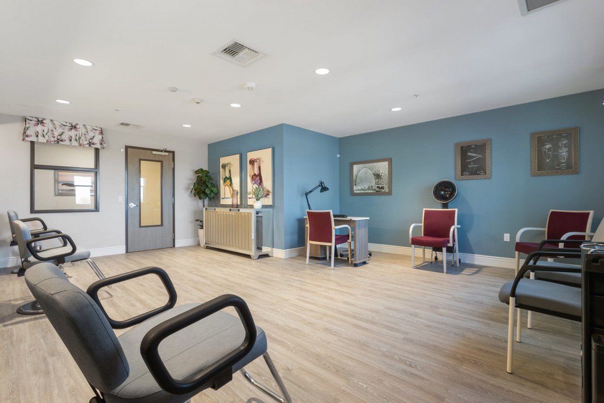 A modern waiting room with chairs and a desk against a blue accent wall.