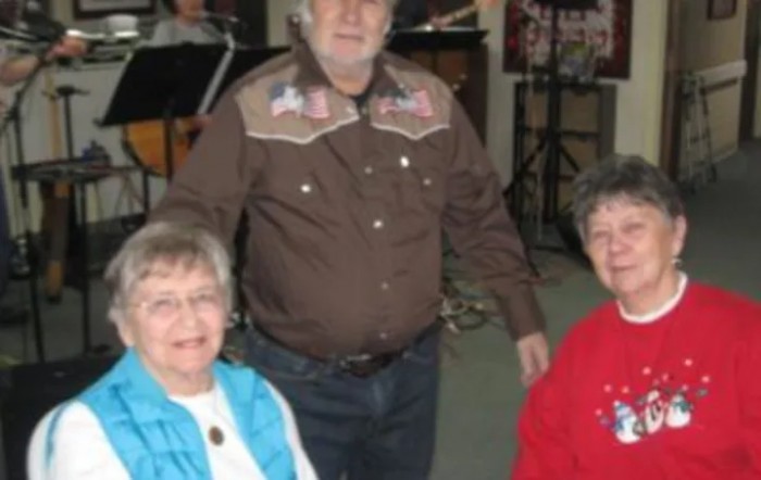 A group of people posing indoors, dressed in casual clothing.
