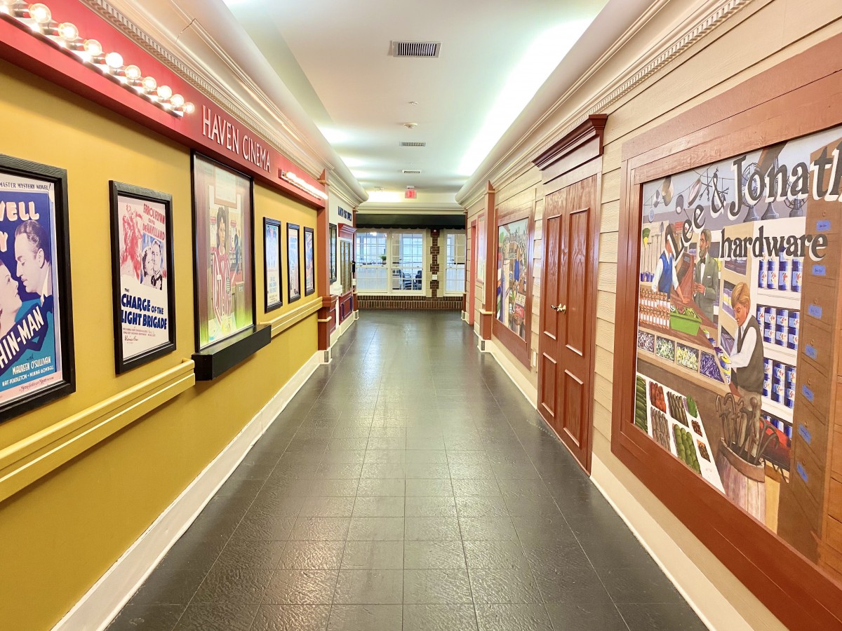 A hallway in an art gallery displaying several framed paintings on the walls.