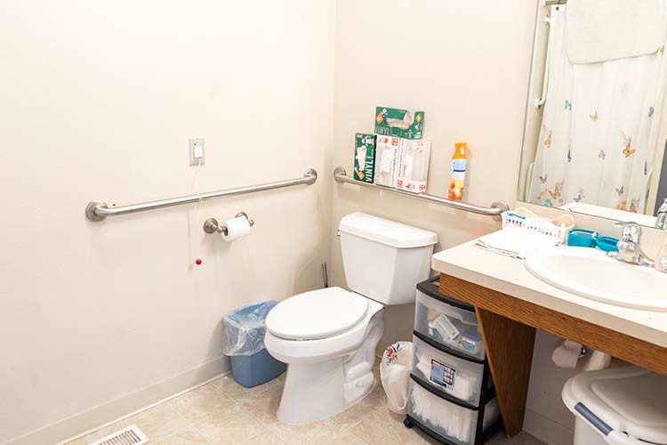 A small bathroom with a toilet, sink, and various toiletries.