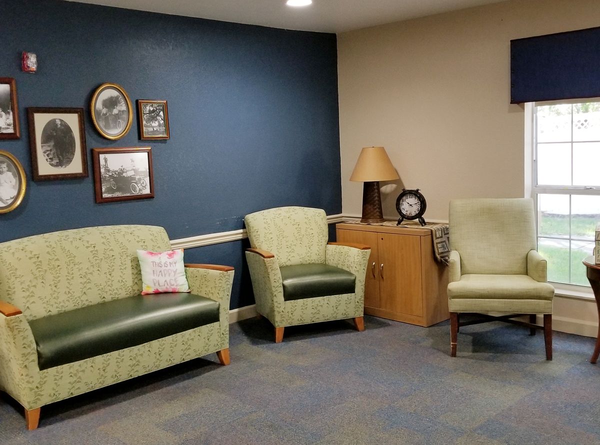 A cozy waiting room with armchairs, a sofa, and wall decor.