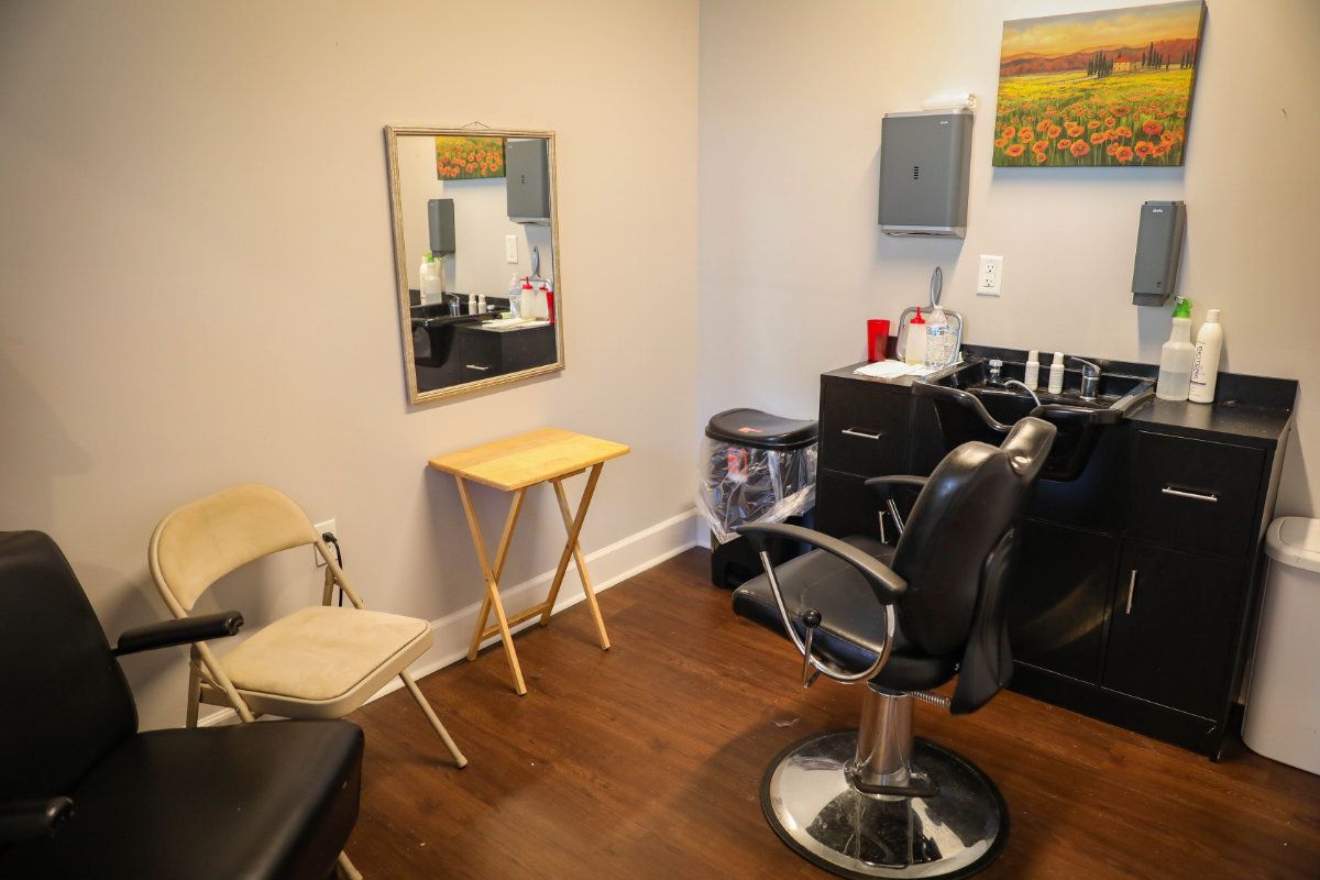 A cozy hair salon setup with a styling chair, mirror, and small table.