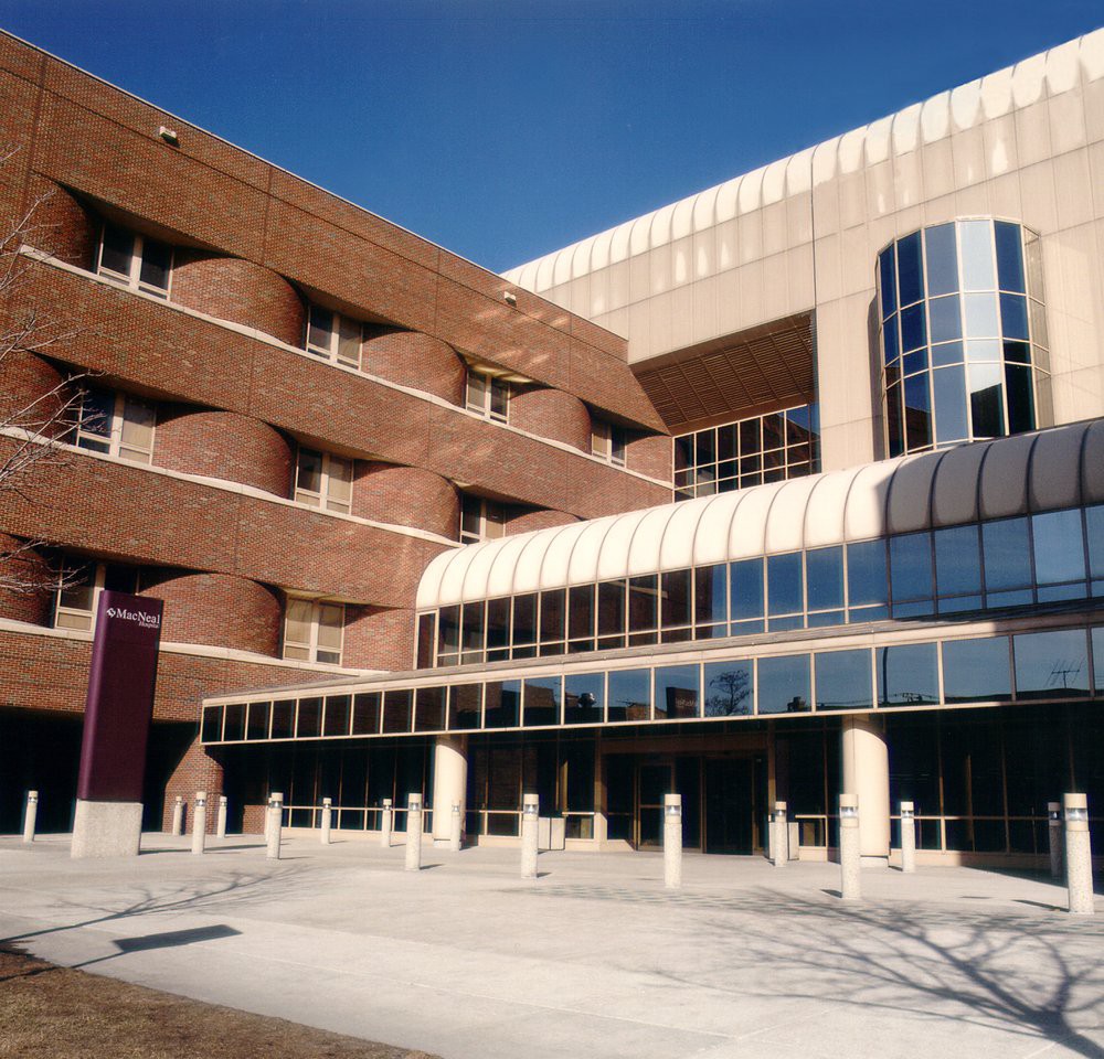 A modern architectural building with brick and glass elements.