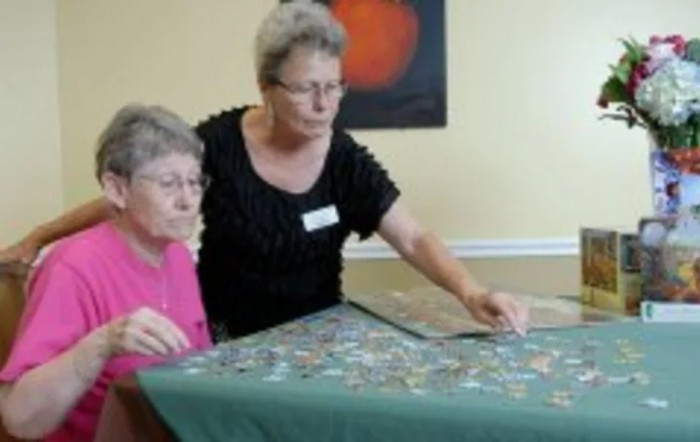 Two women working on a puzzle together at a table.