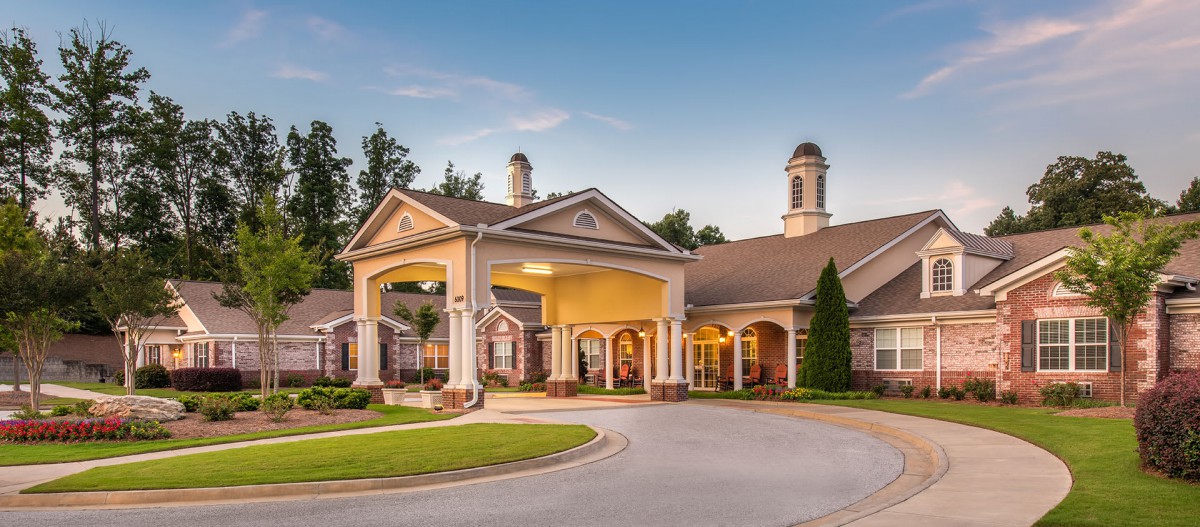 A well-maintained building with a welcoming entrance and landscaped surroundings under a clear blue sky.