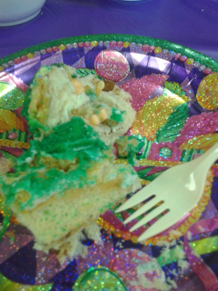 A vibrant slice of cake on a Mardi Gras-themed plate with a fork.