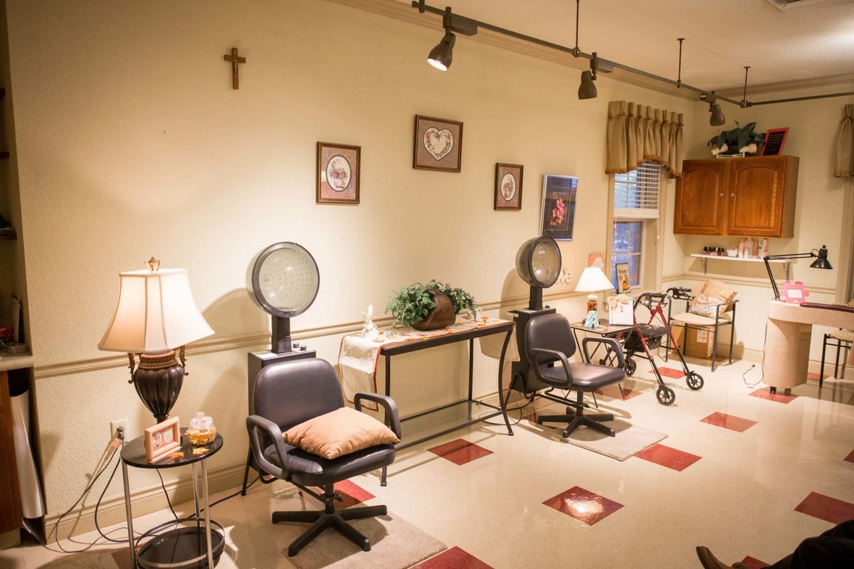 A cozy salon interior with hair dryers, chairs, and warm decor.