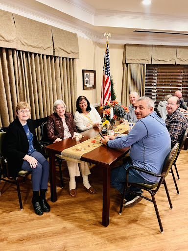 A group of friends gathered for a meeting around a table, sharing moments and conversations.