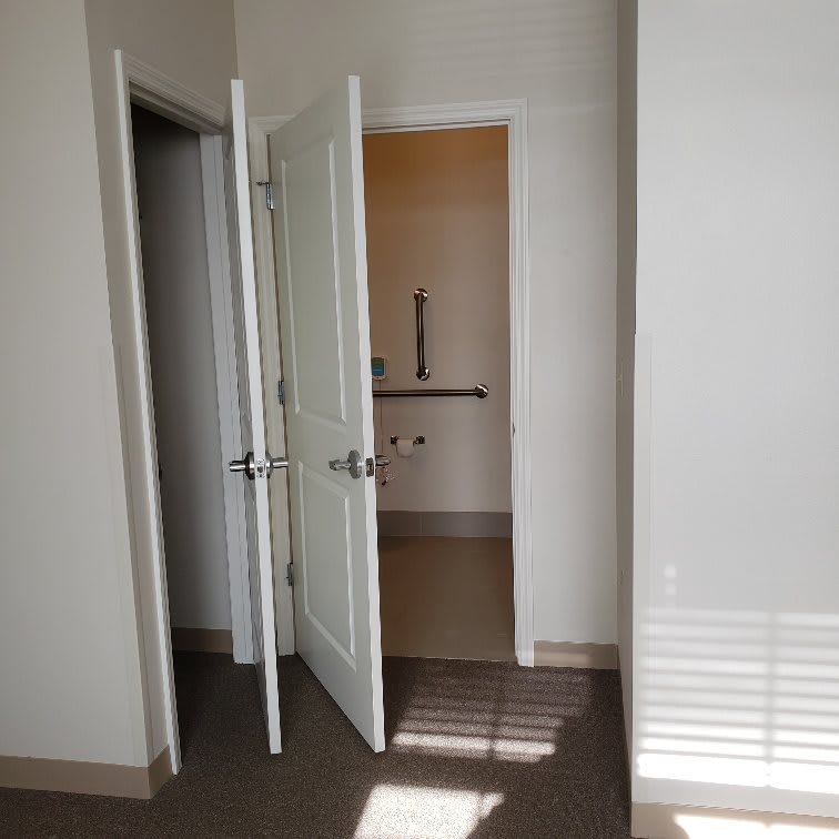 A hallway with open doors casting light and shadows.