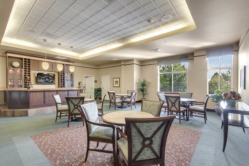 A modern lobby with elegant seating and tables, featuring stylish lighting and large windows.