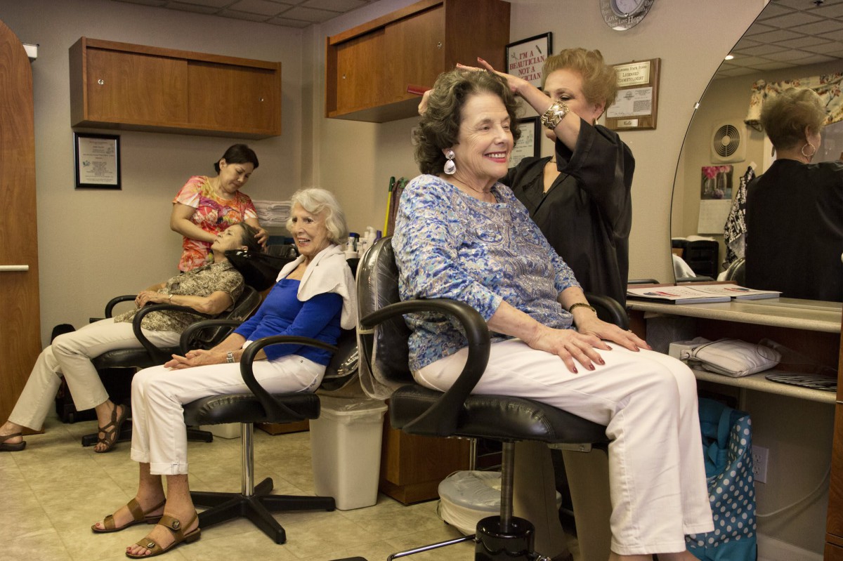 A group of senior women enjoying a day at the hair salon as stylists work on their hair.