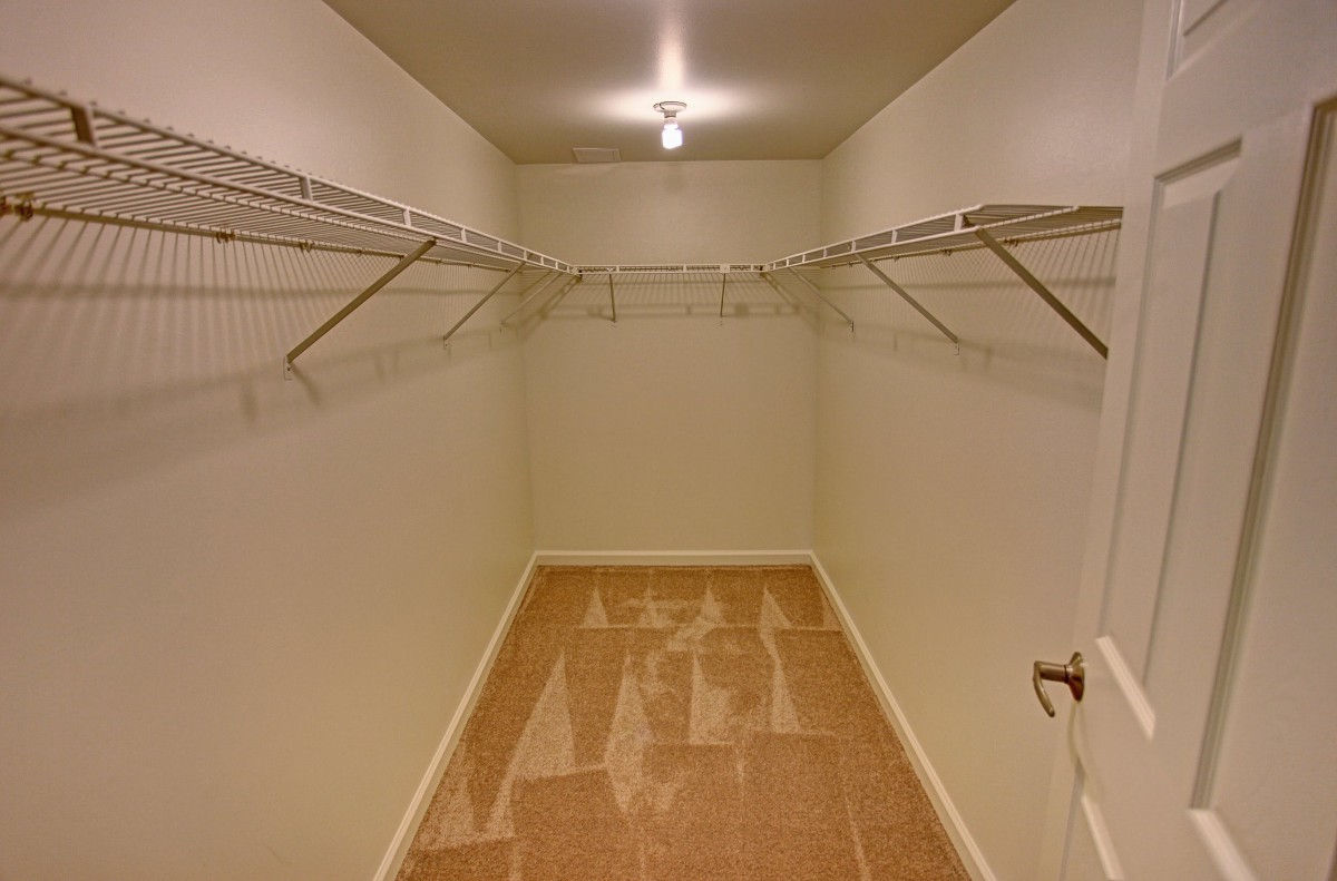 An empty walk-in closet with wire shelving and simple lighting.