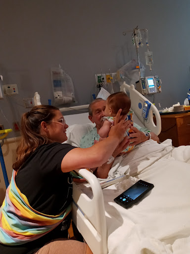 A heartwarming moment of family connection in a hospital room, as a child visits a patient.