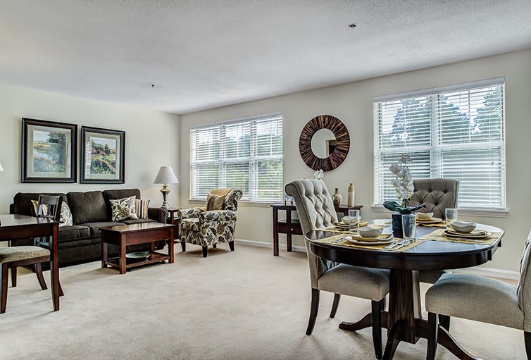 A modern living room and dining area with stylish furniture and ample natural light.