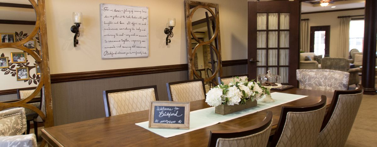 A beautifully decorated dining room with a wooden table, elegant chairs, and floral centerpiece.
