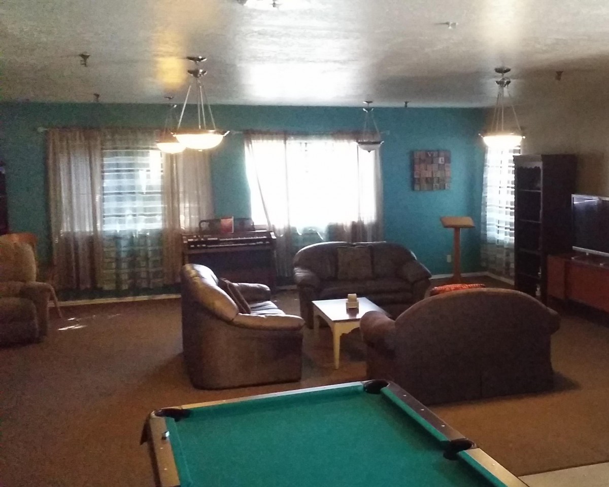 A cozy living room with a pool table and comfortable seating area.