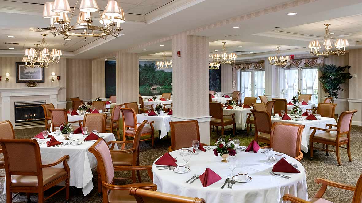 Elegant dining room with neatly set tables and comfortable chairs.