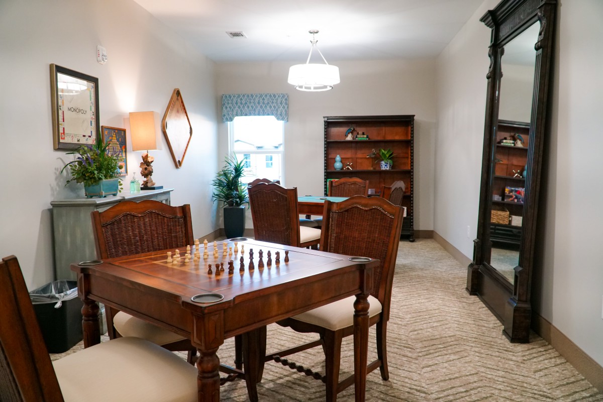 A cozy living room with vintage furniture and a chess set on the table.