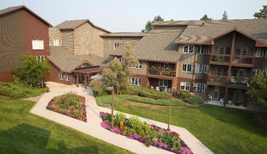 A residential building with a landscaped garden and vibrant flower beds.