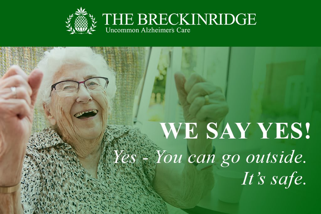 A happy elderly person at The Breckinridge, a dementia assistance care facility, with the message: 'Yes - You can go out. It's okay.'