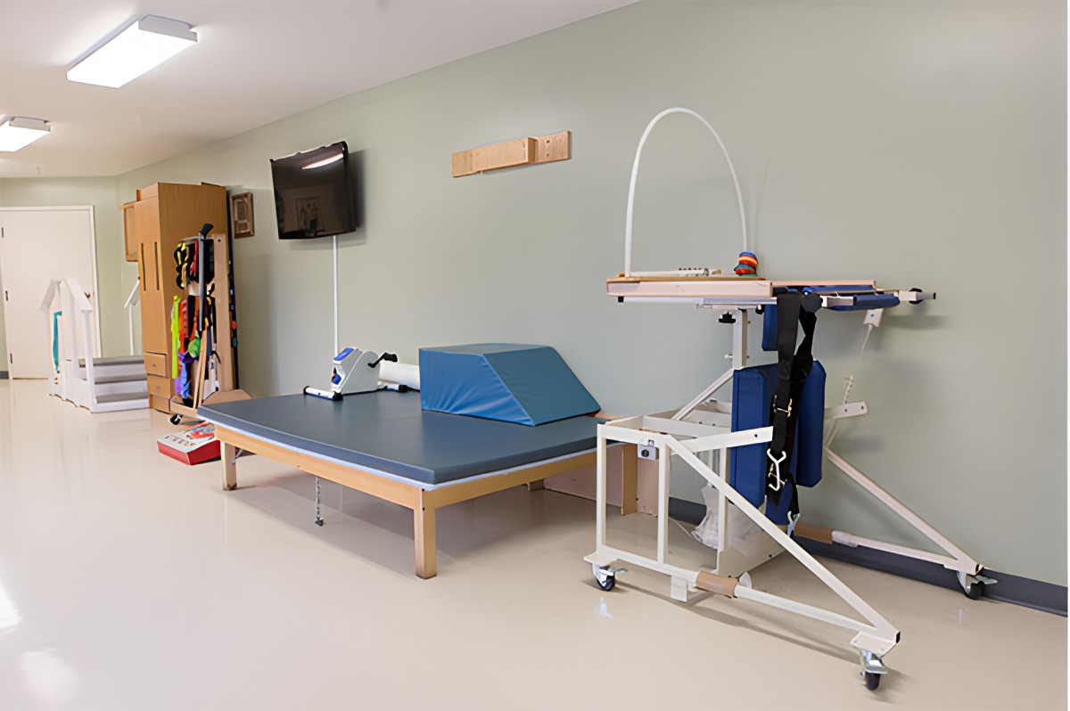 A physical therapy room equipped with exercise equipment and a treatment table.