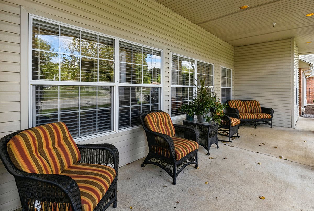 A cozy porch with comfortable seating and plants.