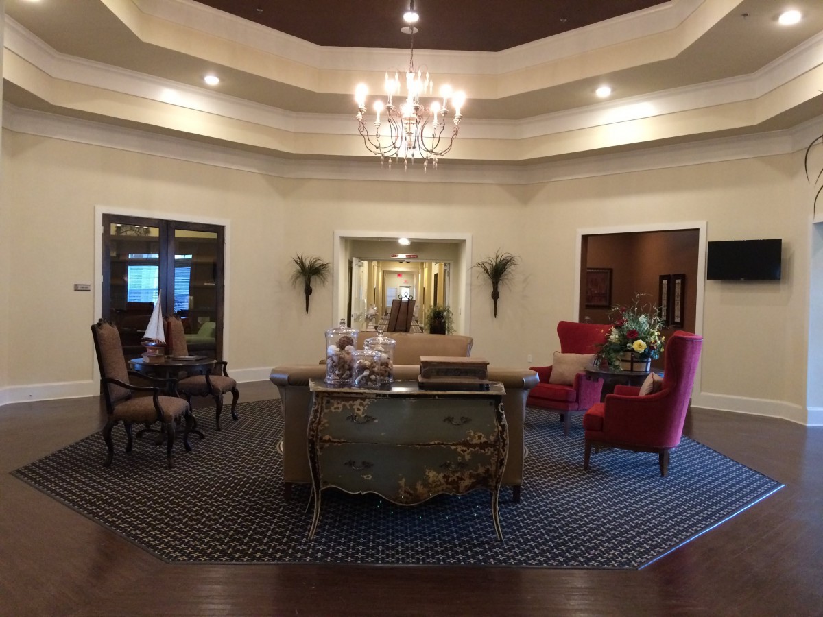 A luxurious lobby with elegant furnishings and a central chandelier.