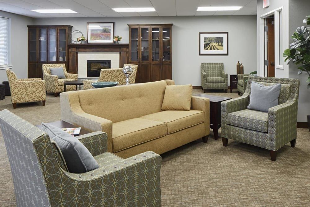 A cozy living room with a sofa, armchairs, and a fireplace.