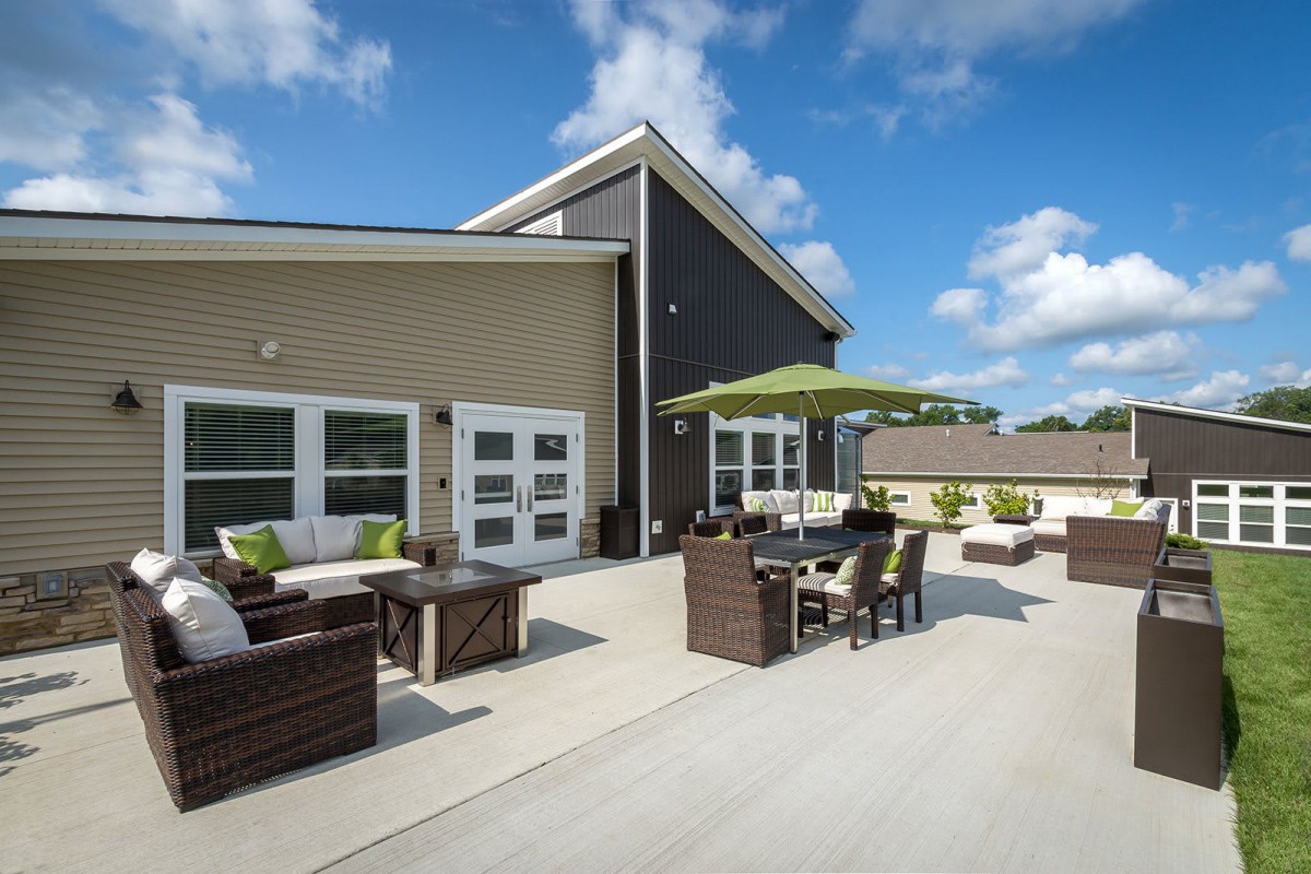 A spacious outdoor patio featuring modern furniture under a sunny sky.