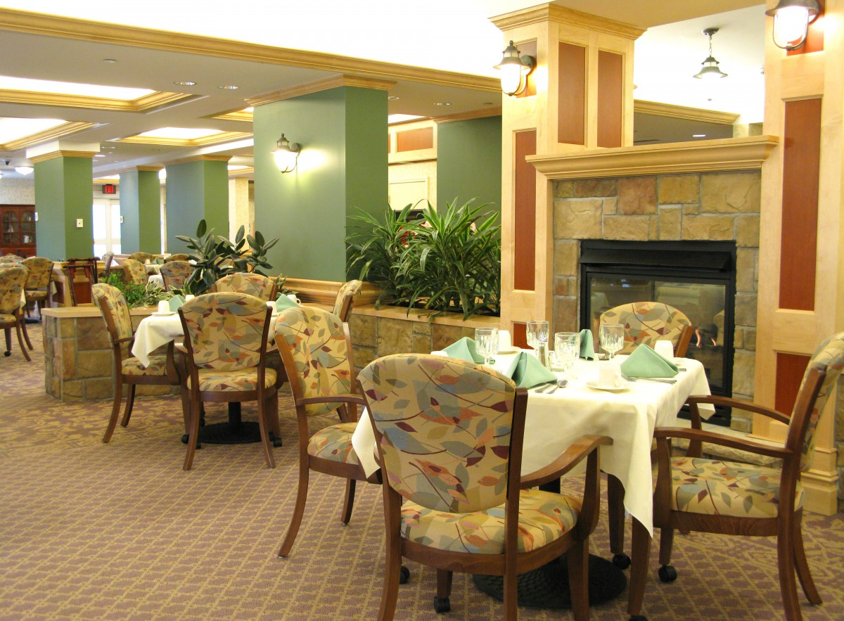 A cozy restaurant dining area with neatly arranged tables and a fireplace.