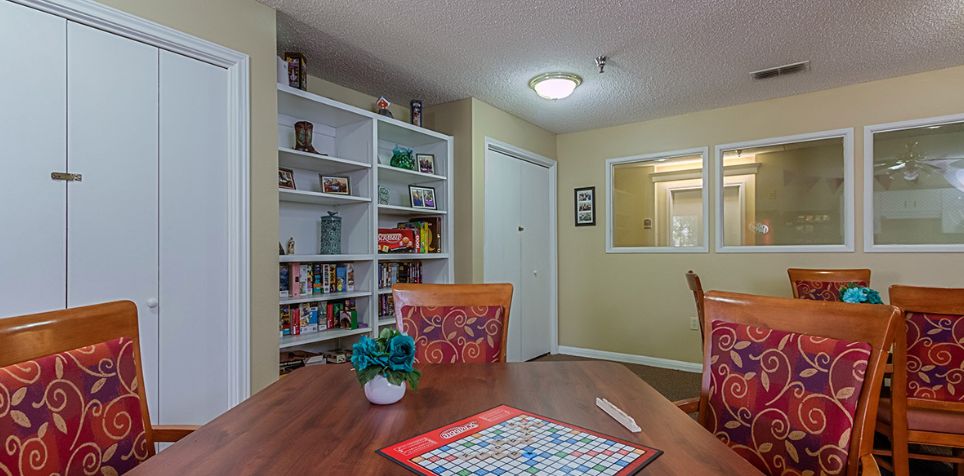 A cozy living room with a bookshelf, table, and a game board on display.