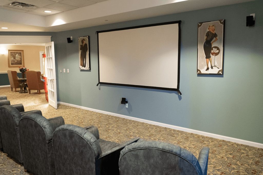 A cozy home theater setup with comfortable seating and a large projector screen.