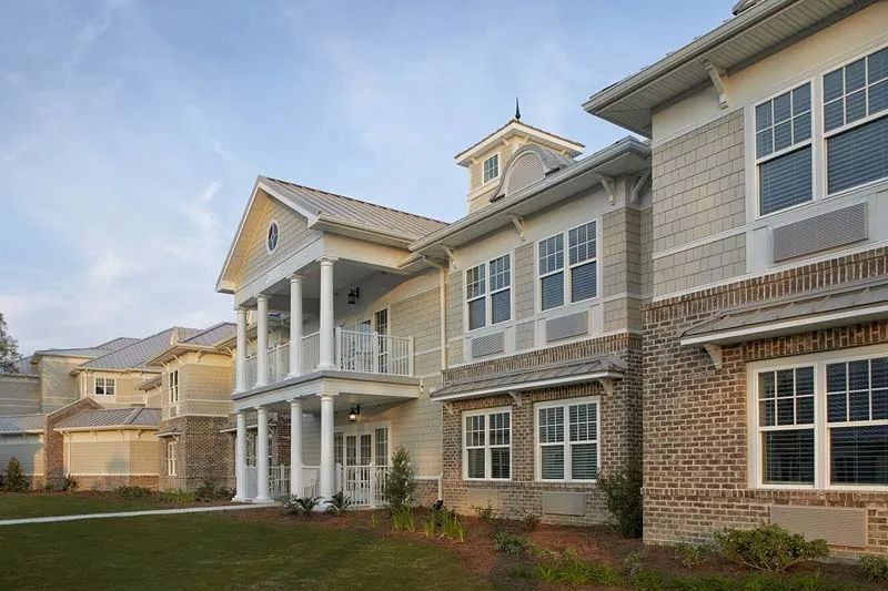A modern residential building with large windows and a porch.