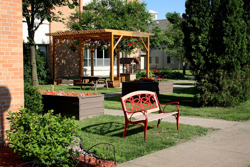 A peaceful outdoor space featuring a decorative bench, pergola, and lush greenery.