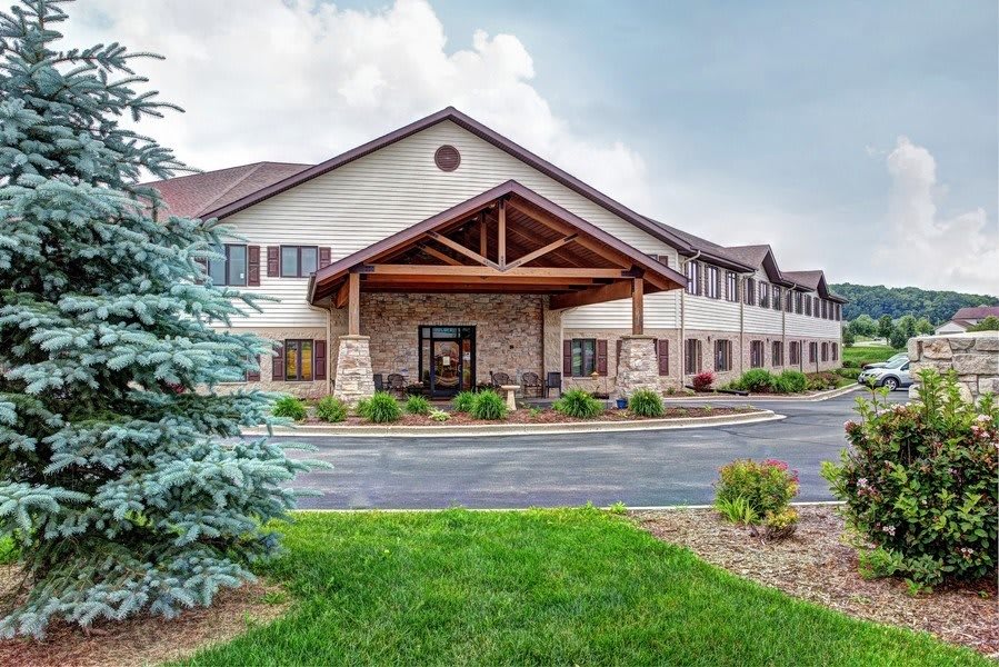 A welcoming hotel with a landscaped entrance and a driveway.