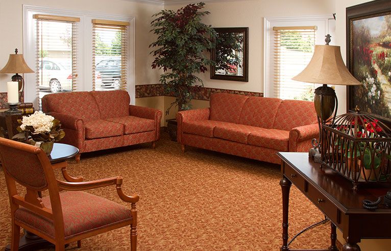 A cozy living room with two sofas, a table, and a floor lamp.