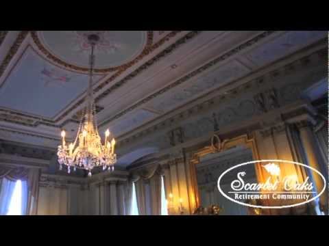 A beautifully ornate ceiling featuring a grand chandelier in an elegant room.
