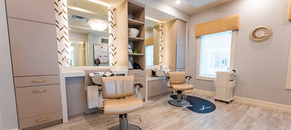 A modern beauty salon interior with stylish chairs and mirrors.