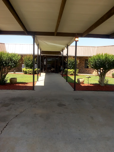 A view of a well-maintained courtyard with a covered pathway and landscaped greenery.
