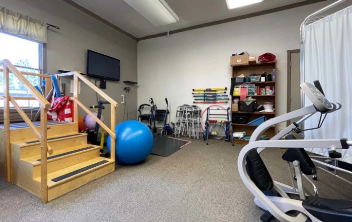 A physical therapy room equipped with various rehabilitation tools and exercise equipment.