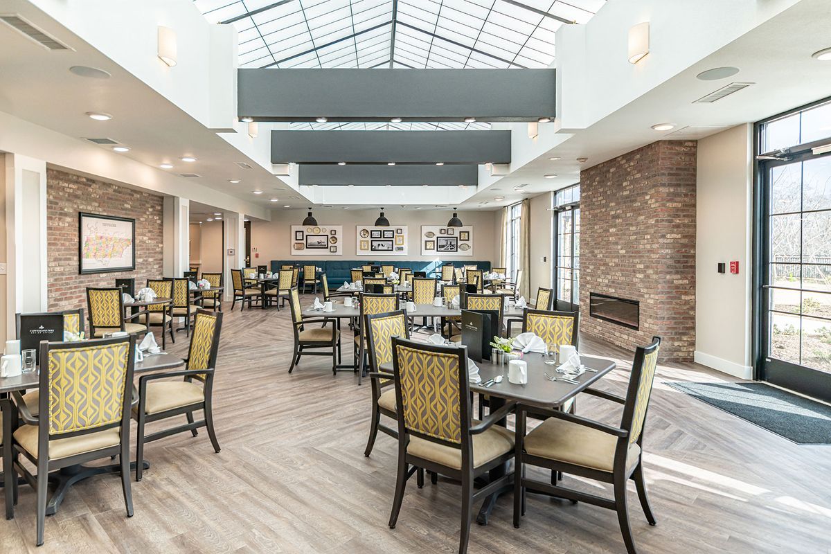 A modern dining area with stylish furniture and a skylight ceiling.