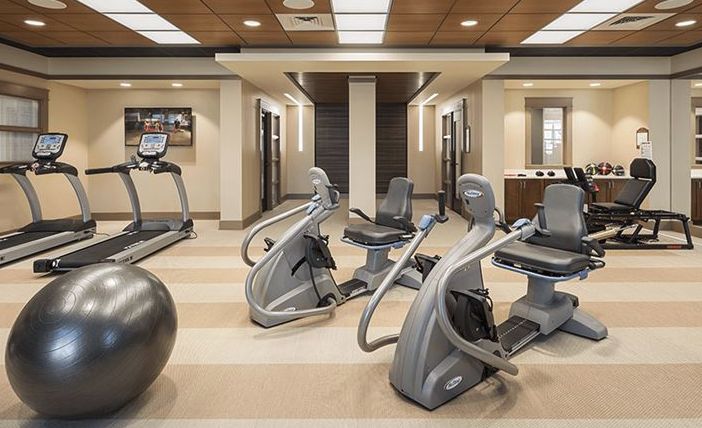 A modern gym with various fitness equipment and exercise machines arranged neatly.